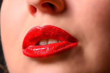 Female lips close-up with glossy red lipstick
