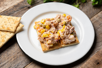 Tuna salad with mayonnaise on wooden background