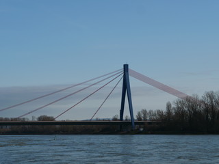 Fototapeta na wymiar elegant suspension bridge across river against clear sky