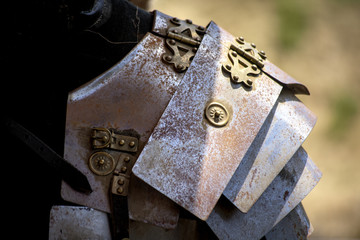Close-up view of some rusty roman body armour with gold rivets
