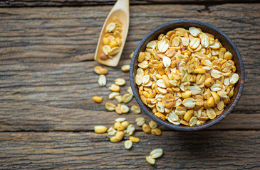 Roasted peanuts in bowl with wooden background