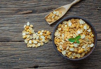 Roasted peanuts in bowl with wooden background