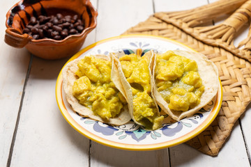 Mexican scrambled eggs tacos with green sauce on white background