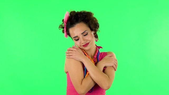 Girl posing, gently stroking her skin and attractively looking at the camera. Green screen