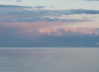 Pink and Blue Rain Clouds Over the Calm Water at Sunset
