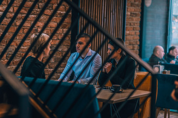 Obraz na płótnie Canvas Business meeting inside a cafe with the focus through a fence.
