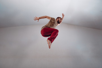 Naklejka premium Modern dance performer practicing modern dance on white wall