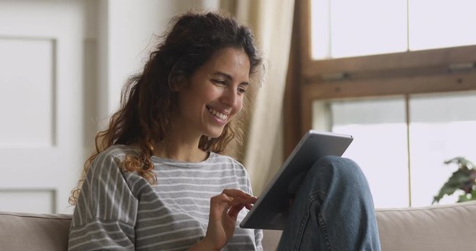 Smiling attractive woman using dating application on digital tablet.