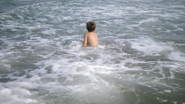 Child running in the sea, boy have fun