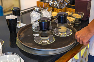 Traditional Vietnamese dripping filter milk coffee served with ice