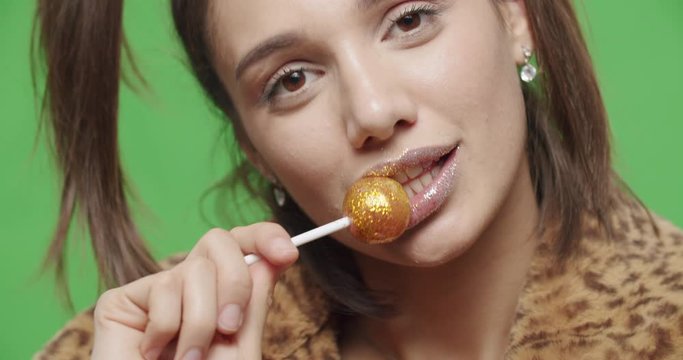 female model wearing leopard fur coat licking candy