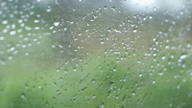 Closeup 4k video of old dirty window with rain water droplets in passenger train