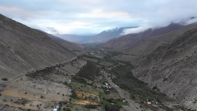 An aerial view inside Andes mountains at Limari Valley, south Atacama. An amazing wild scenery. Arid idyllic valleys with green farm fields feed in by the river at the bottom of the valley
