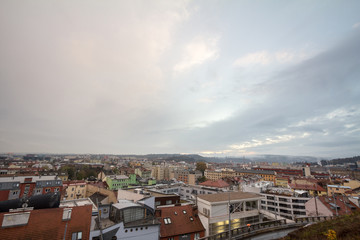 Aerial panorama of Brno, Czech Republic, with a focus on a residential suburb with panelaky towers in background, from the roofs of houses. Brno is the second biggest Czech city