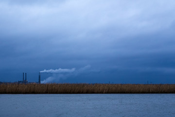 Obraz na płótnie Canvas Smoke stacks in the distance across the bay