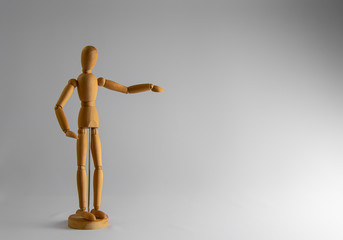 Wooden dummy stands on white background with hand raised