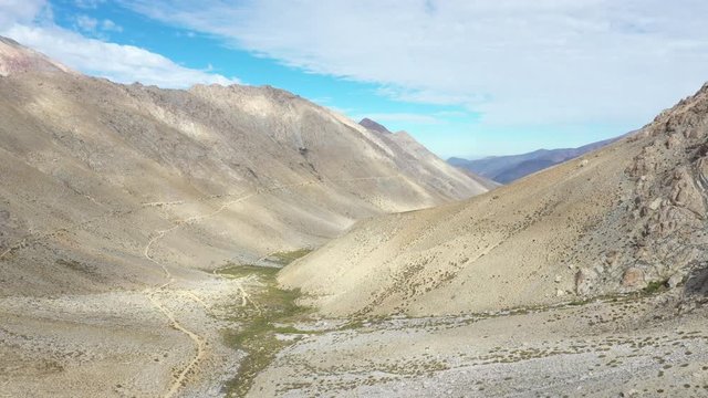 An aerial view inside Andes mountains at Limari Valley, south Atacama. An amazing wild scenery. Arid idyllic valleys with green farm fields feed in by the river at the bottom of the valley
