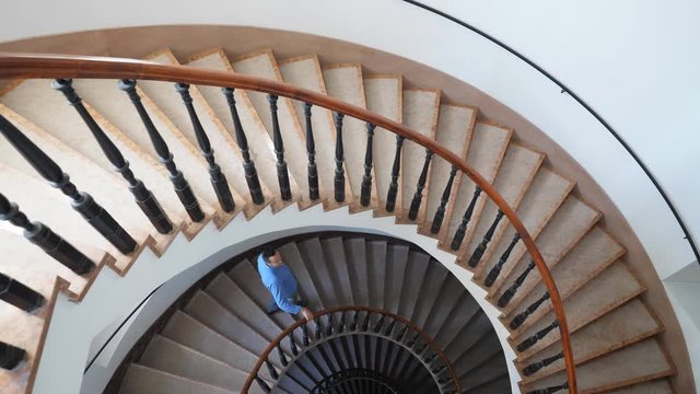 Tourist stepping down on spiral stairs and admire the architecture