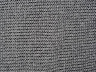 Gray knitted textured background, knit with facial loops. Hand knitting.