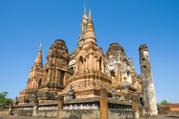 Obraz premium Ruins of chedi of the Buddhist temple Wat Mahathat close up on a sunny day. Sukhothai, Thailand