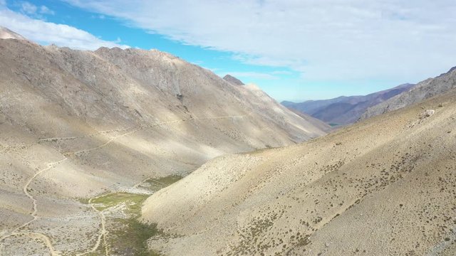 An aerial view inside Andes mountains at Limari Valley, south Atacama. An amazing wild scenery. Arid idyllic valleys with green farm fields feed in by the river at the bottom of the valley
