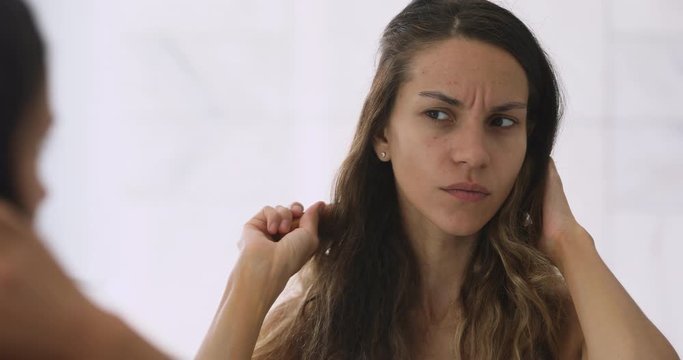 Stressed woman worrying about damaged messy hair.