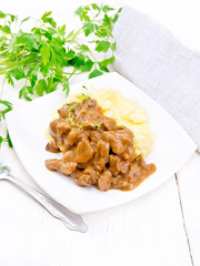 Goulash of beef with mashed potatoes in plate on table