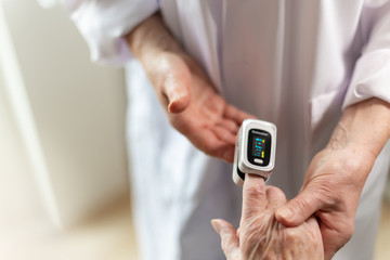 Rentnerin bekommt eine Sauerstoff Messung mit dem Oximeter