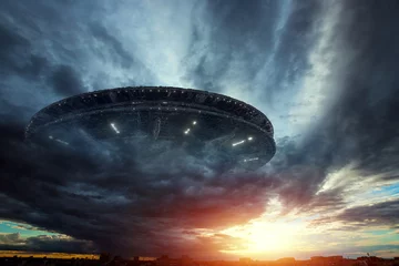 Abwaschbare Fototapete UFO UFO, eine außerirdische Platte erhebt sich am Himmel und schwebt bewegungslos in der Luft. Nicht identifiziertes Flugobjekt, außerirdische Invasion, außerirdisches Leben, Raumfahrt, humanoides Raumschiff. gemischtes Medium