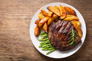 Foto auf Alu-Dibond Teller mit gegrilltem Steak mit Rosmarin, Spargel und Kartoffeln, Draufsicht © Nitr