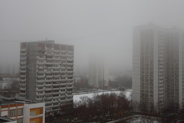 Fog over the city, high-rise buildings in gray mist in the Moscow district Konkovo
