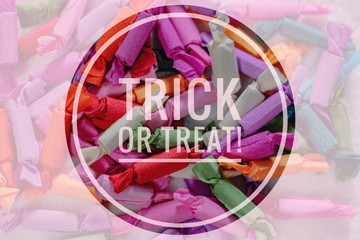 Trick or Treat Halloween Typography Background against colorful wrapped candy treats