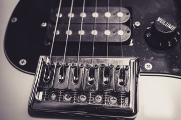 Top view of an electric guitar bridge, pickups and volume control button