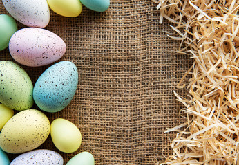 Easter eggs on sackcloth and straw.