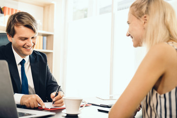 The interview scene with the interviewer writing a note down to the clipboard while asking questions from a woman candidate, concept recruitment new employee, job interview nervousness.