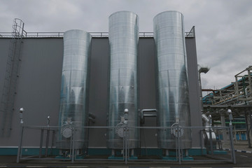 Three tanks at a chemical plant. Tanks at a chemical plant. Day view. Chemical production of mineral fertilizers, nitrogen, ammonium, phosphorus fertilizers. © Aleksandr