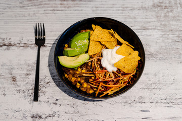 vegan mexican bowl with beans avocado tortilla chips and coleslaw veggies with cashew yoghurt