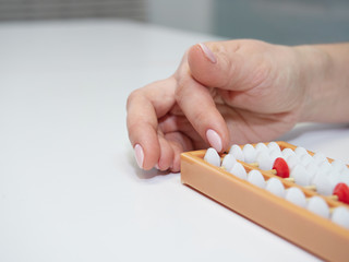 Classes in mental arithmetic, hands and abacus soroban on white background. closeup. copy space