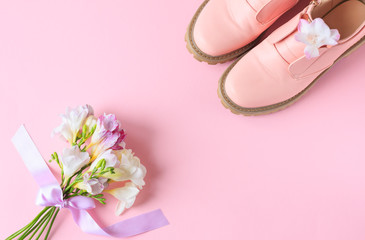 a bouquet of spring flowers and women's pink shoes are on the table, a place for text, a spring concept