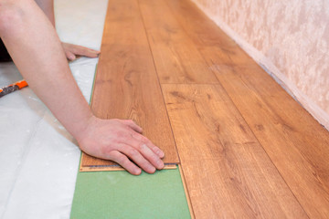 Man stacks a parquet board. Repair floor work in the apartment. Repair concept.