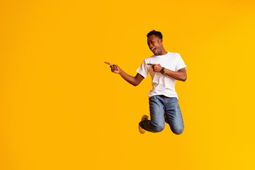 Excited emotional african man jumping over yellow background