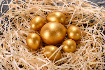 Easter golden eggs in the nest, preparation for the holiday