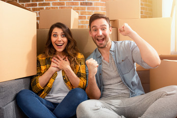 Happy couple have found a new home and they need to arrange all the packages. Concept of success,...