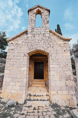 Ancient small catholic chapel made from stones with tiled roof.