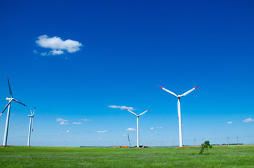Wind turbines on green field blue sky clouds green energy concept renewable energy generator