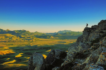 Beautiful panorama. View of the valley and mountains. Hiker in the mountains. Good sunset light. Spring. Background image. Lifestyle.