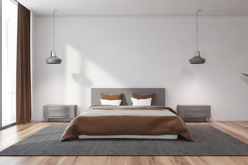 White master bedroom interior with brown bed