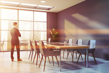 Businessman in gray cafe interior with blue chairs