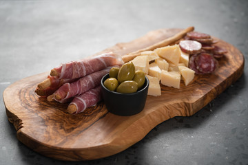 Italian snacks on olive wood board