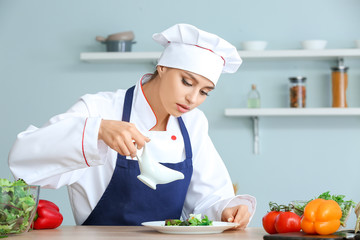 Female chef making fresh salad in kitchen